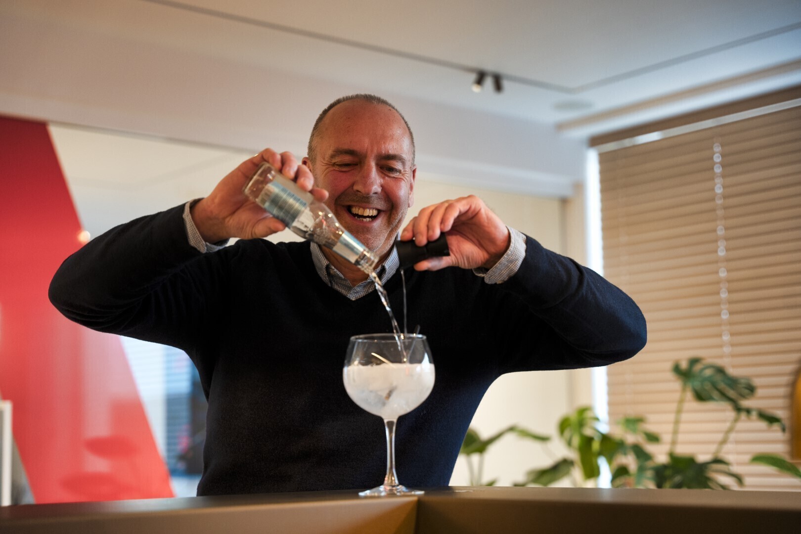 personeelslid schenkt een gin in