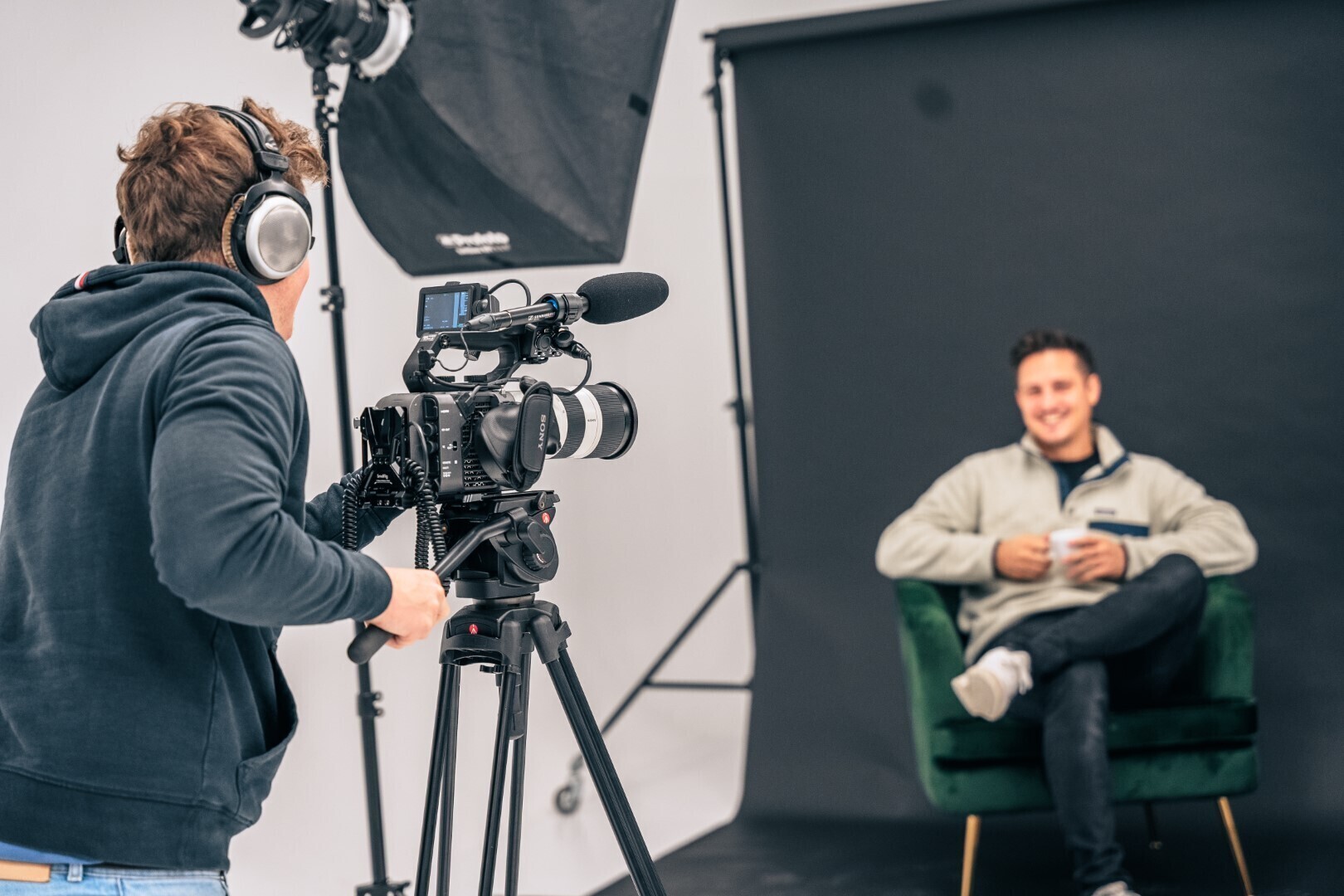 Een professionele videograaf die een man aan het filmen is voor een zwart scherm