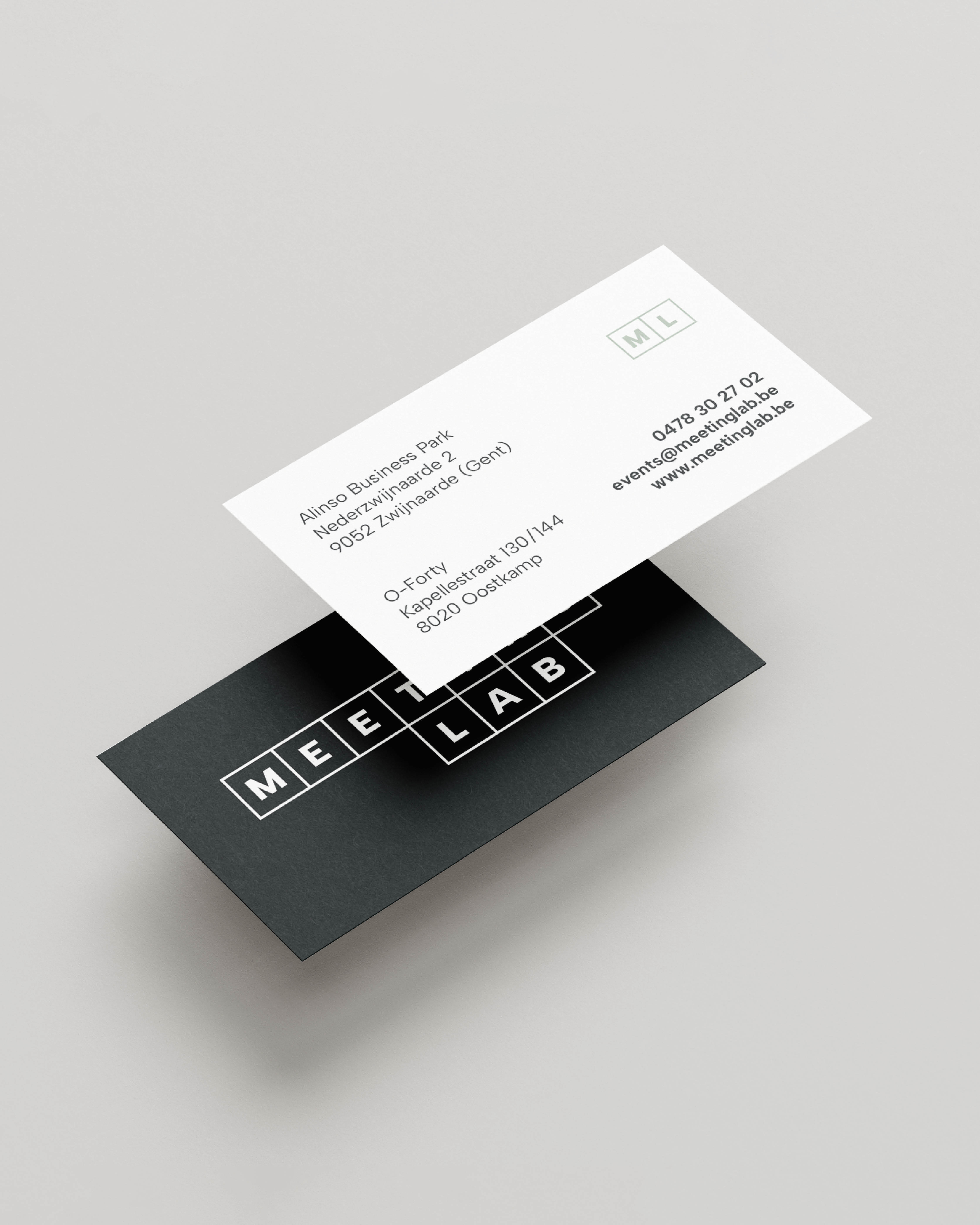 Twee zwevende visitekaartjes van Meeting Lab, één met het logo op zwarte achtergrond en één met contactgegevens op witte achtergrond.